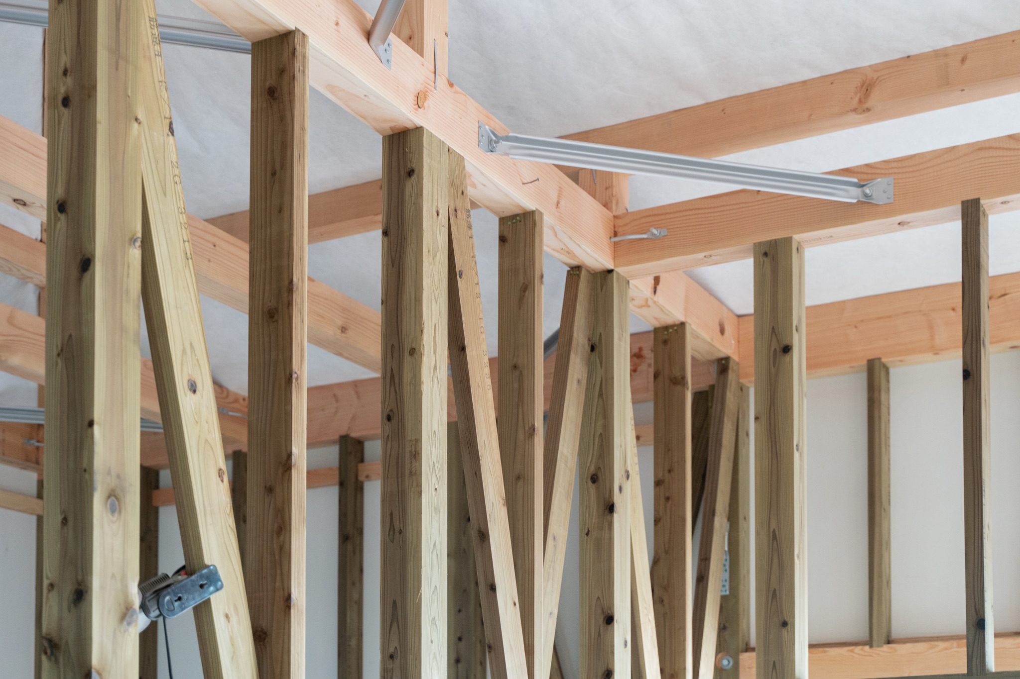 柱と筋交いが並ぶ、建築中の住まいの構造
