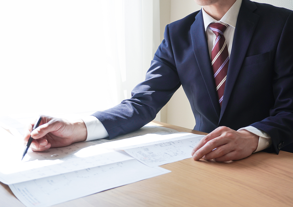 新築注文住宅の契約について説明する営業マン